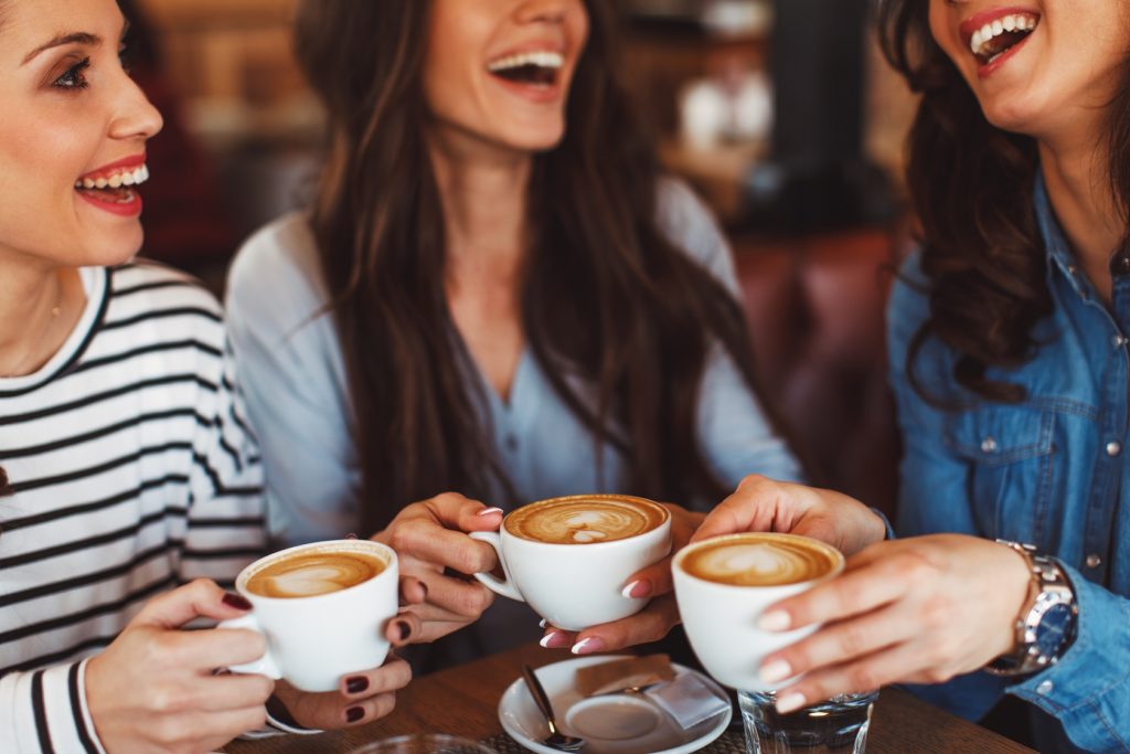Three women chatting and drinking coffee