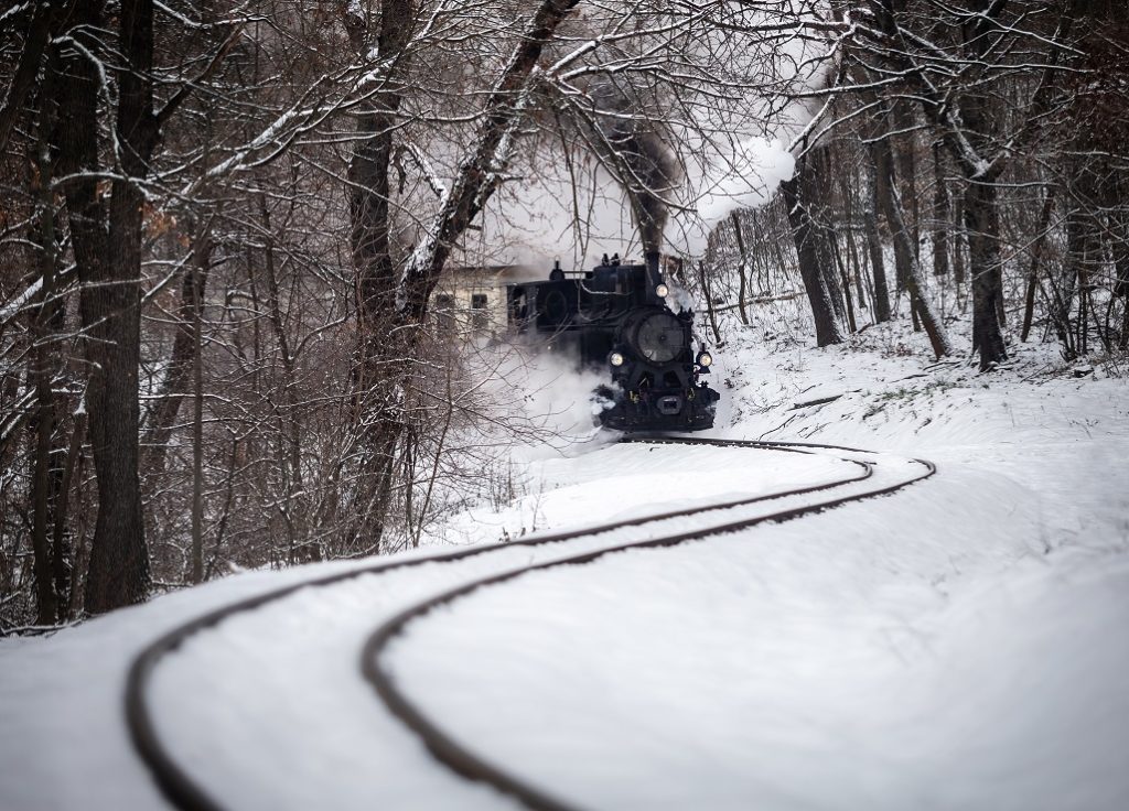 Steaming train pushing through the snow in February.
