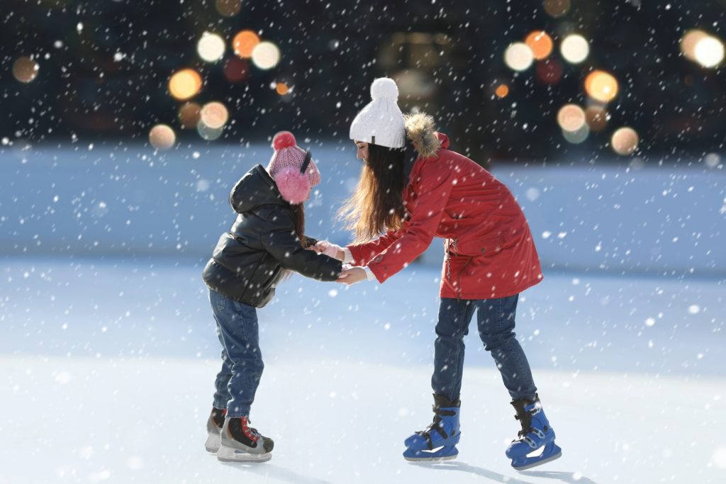 Mom and daughter at an outdoor skating rink in January